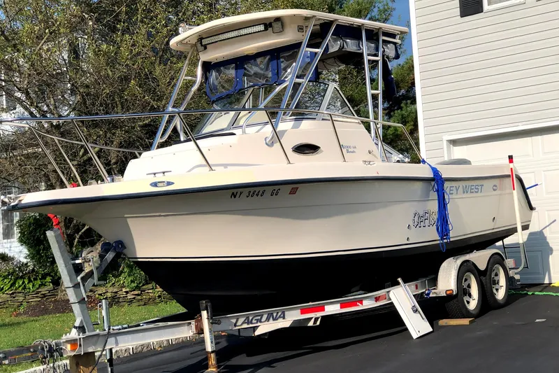 Slide: The Image of 2005 Key West 2300 WA boat on a trailer in a driveway. - 1