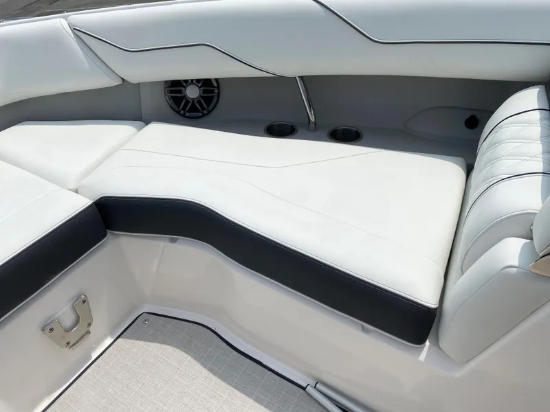 Slide: The Image of 2025 Regal LX4 boat interior with white seating, cup holders, and speaker. - 9