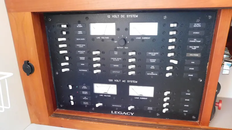 Slide: The Image of Electrical control panel of 2005 Legacy Yachts 28 Express, featuring 12V DC and 120V AC systems. - 14