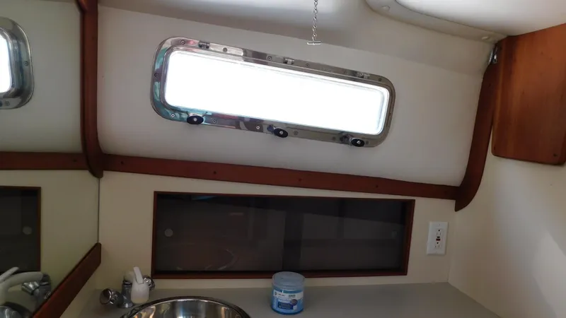 Slide: The Image of 2005 Legacy Yachts 28 Express cabin interior with sink and porthole window. - 15