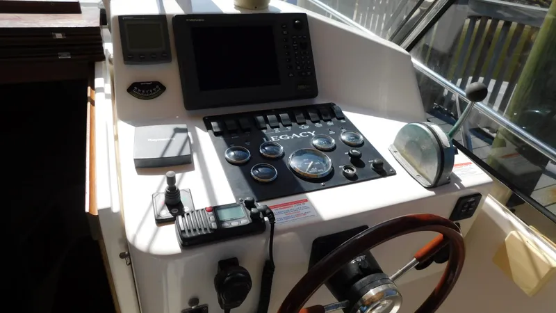 Slide: The Image of 2005 Legacy Yachts 28 Express helm with navigation instruments and steering wheel. - 16