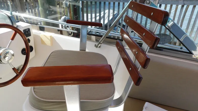Slide: The Image of Captain's chair on a 2005 Legacy Yachts 28 Express boat with wooden armrests. - 18