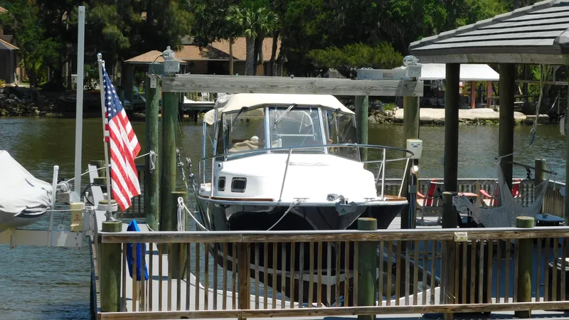 Slide: The Image of 2005 Legacy Yachts 28 Express docked at a marina with an American flag. - 2
