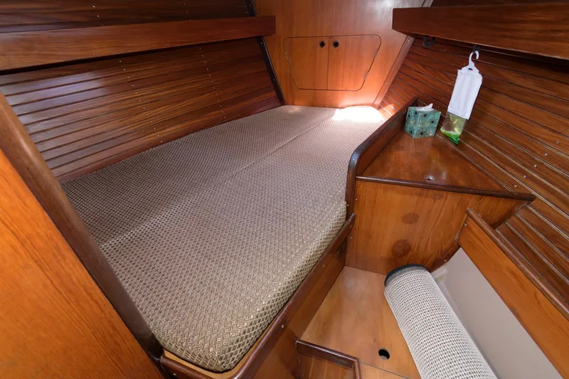 Slide: The Image of 1985 Beneteau 42 First cabin interior with wooden finish and cozy bed. - 11