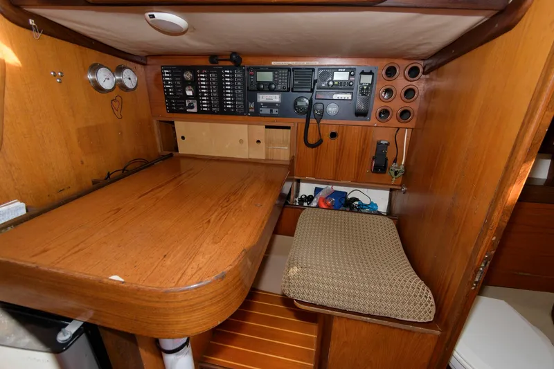 Slide: The Image of Navigation station on a 1985 Beneteau 42 First sailboat with wooden desk and control panel. - 12