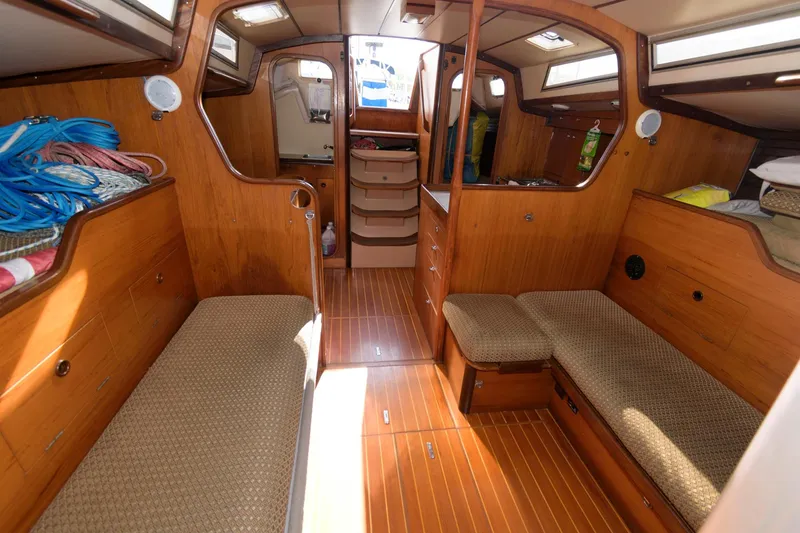 Slide: The Image of Interior of 1985 Beneteau 42 First sailboat with wooden finish and cozy seating. - 7