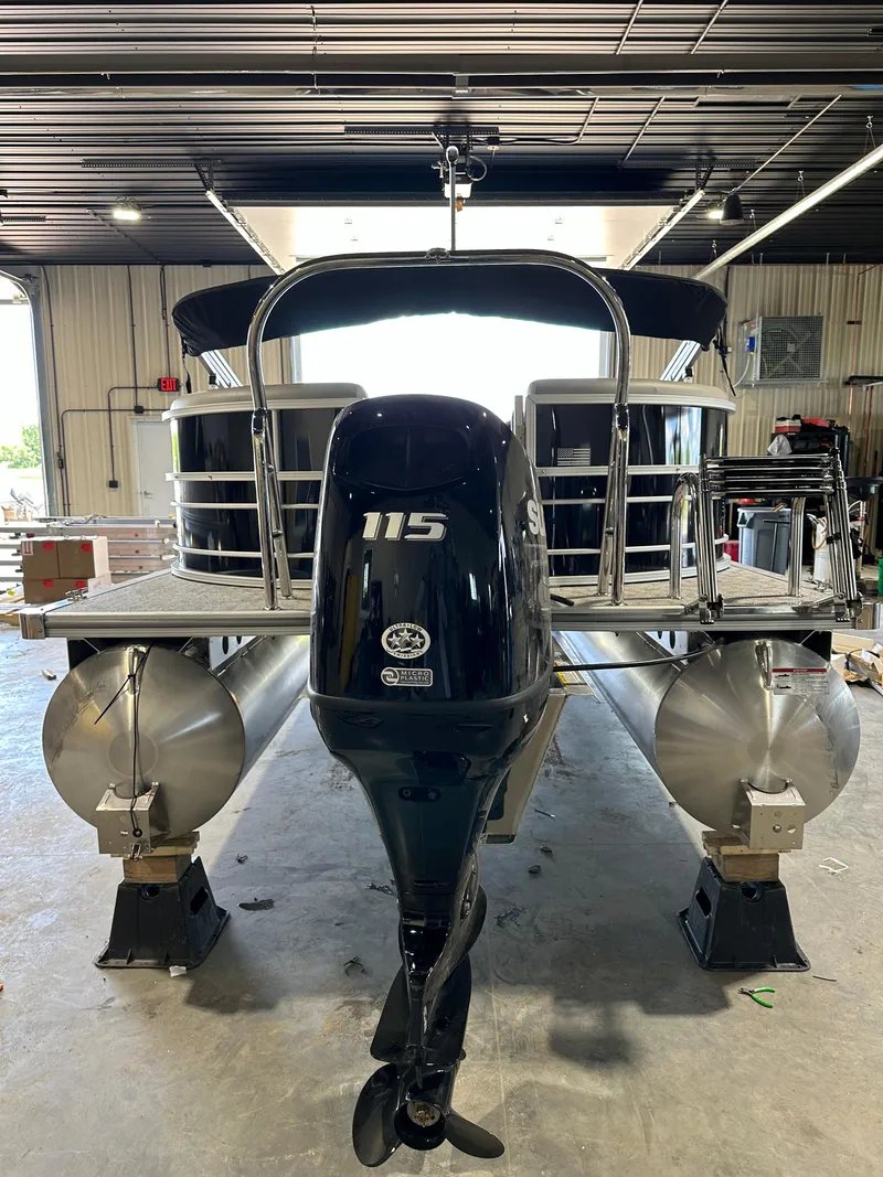 Slide: The Image of 2024 South Bay 224RSLE pontoon boat with 115 HP outboard motor in a garage. - 11