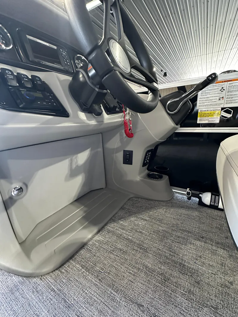 Slide: The Image of 2024 South Bay 224RSLE boat interior cockpit with steering wheel and controls. - 9