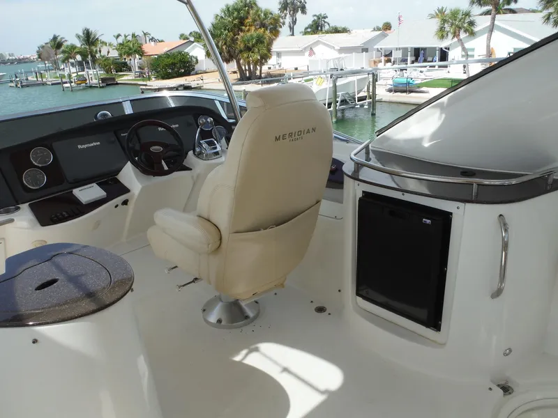 Slide: The Image of 2014 Meridian 441 Sedan boat helm with captain's chair and waterfront view. - 38