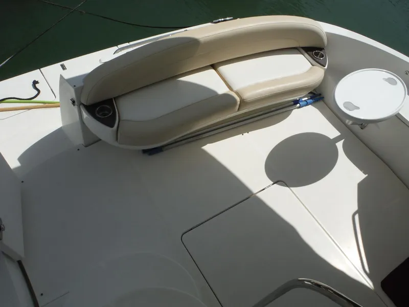 Slide: The Image of 2014 Meridian 441 Sedan boat seating area with white cushioned bench and small table. - 39