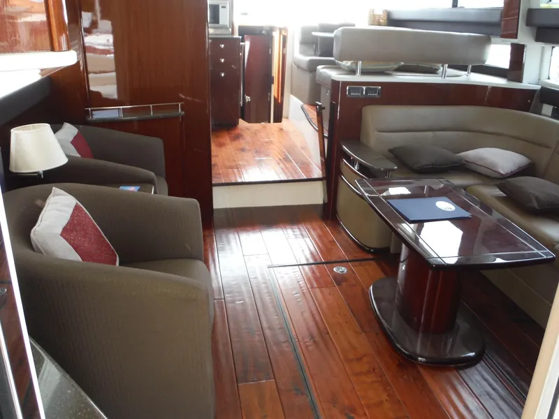 Slide: The Image of 2014 Meridian 441 Sedan yacht interior with polished wood flooring and modern seating area. - 5