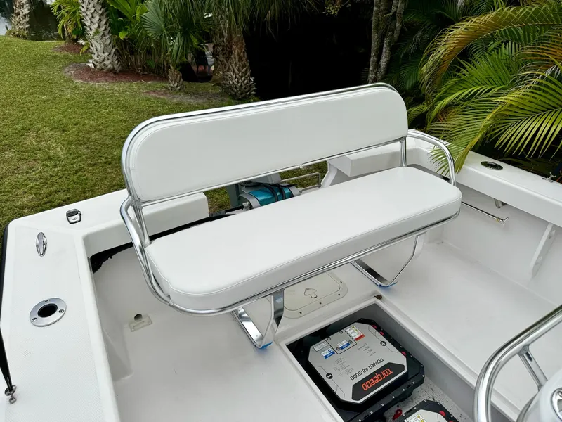 Slide: The Image of 2024 Rambo 22 Center Console boat with white cushioned seating and battery compartment. - 16