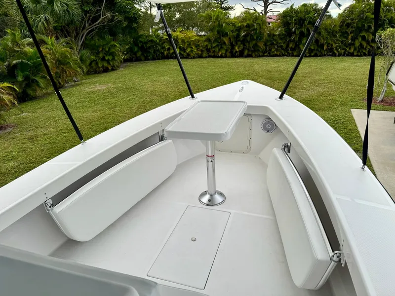 Slide: The Image of 2024 Rambo 22 Center Console boat with white seating and table in a grassy yard. - 18