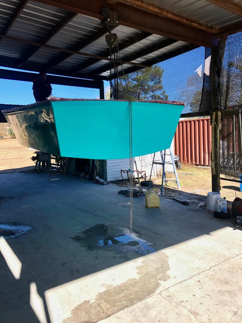 Slide: The Image of 2024 Rambo 22 Center Console boat in a covered outdoor workshop. - 32