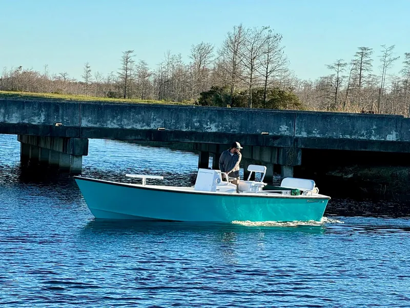 Slide: The Image of 2024 Rambo 22 Center Console boat cruising under a bridge on a calm river. - 9