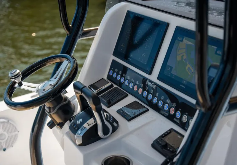 Slide: The Image of 2025 Sea Cat 26 Hybrid Catamaran dashboard with steering wheel and navigation screens. - 2