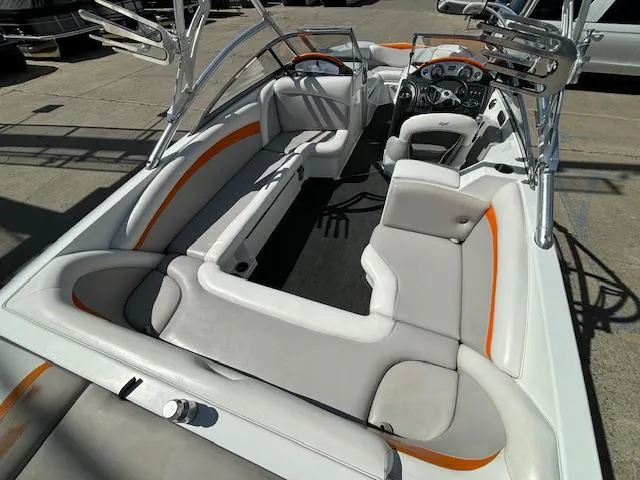 Slide: The Image of 2008 Tigé RZR 24 boat interior with white and orange seating, steering console. - 11