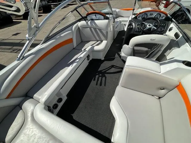 Slide: The Image of 2008 Tigé RZR 24 boat interior with white and orange seating, steering console, and wakeboard tower. - 12