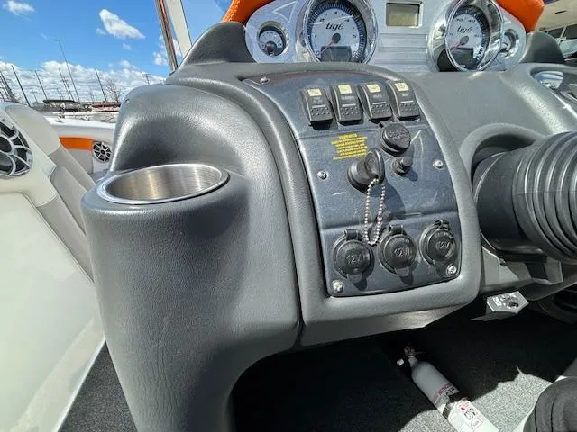 Slide: The Image of 2008 Tigé RZR 24 boat dashboard with controls and cup holder. - 19