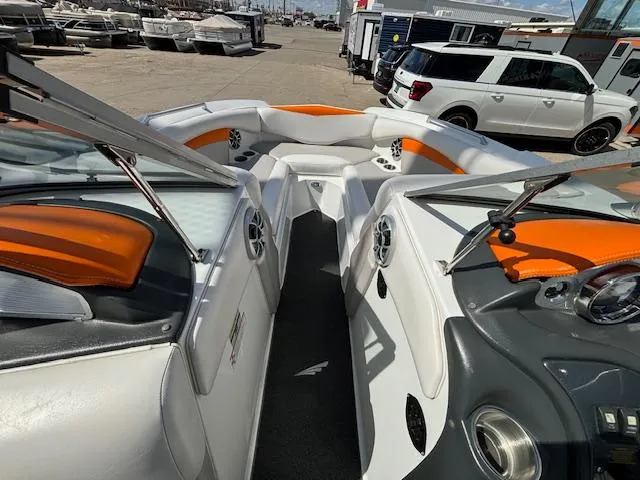 Slide: The Image of 2008 Tigé RZR 24 boat interior with orange and white seating, docked at marina. - 23