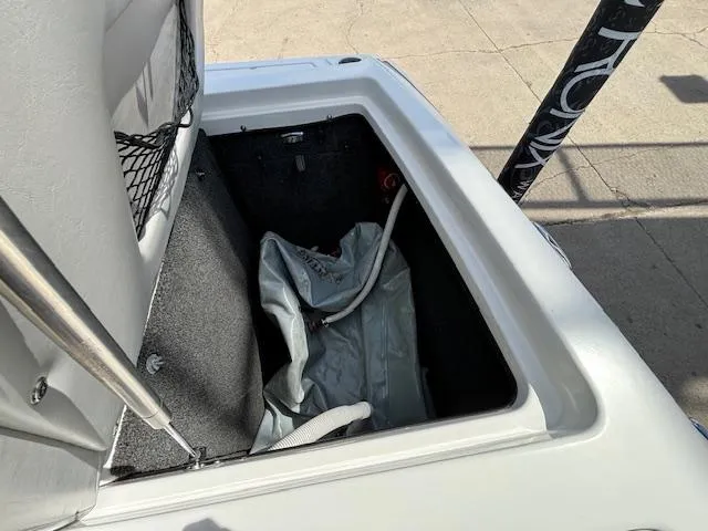 Slide: The Image of Storage compartment of a 2008 Tigé RZR 24 boat with a gray cover inside. - 33