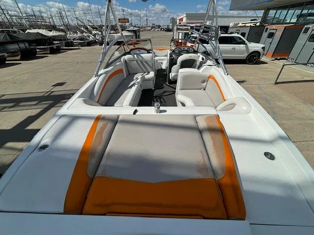 Slide: The Image of 2008 Tigé RZR 24 boat with orange and white interior, docked at a marina. - 9