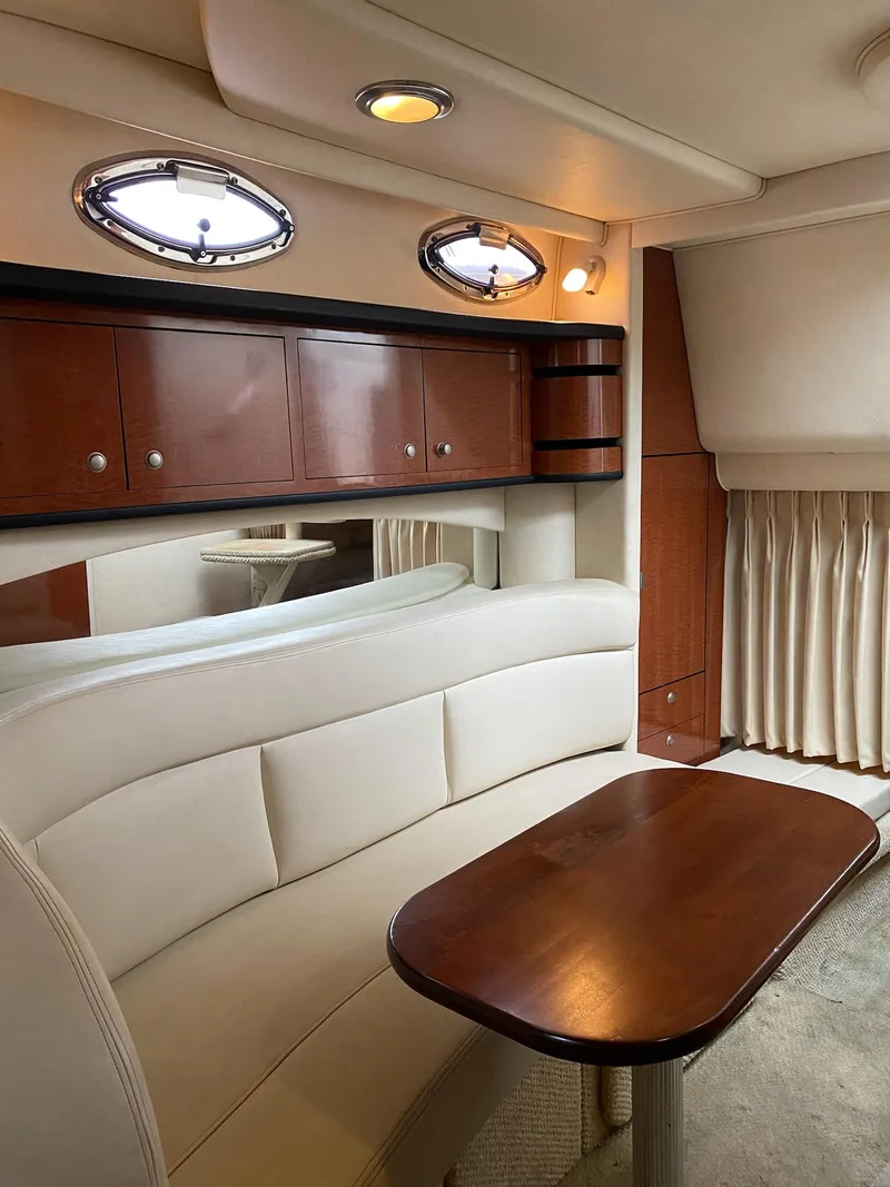 Slide: The Image of Luxurious interior of 2005 Sea Ray SUNDANCER 300 yacht with white seating and wooden table. - 2