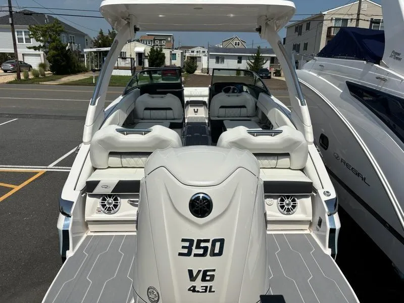 Slide: The Image of 2025 Regal LX6 boat with V6 4.3L engine, rear view in a marina. - 2