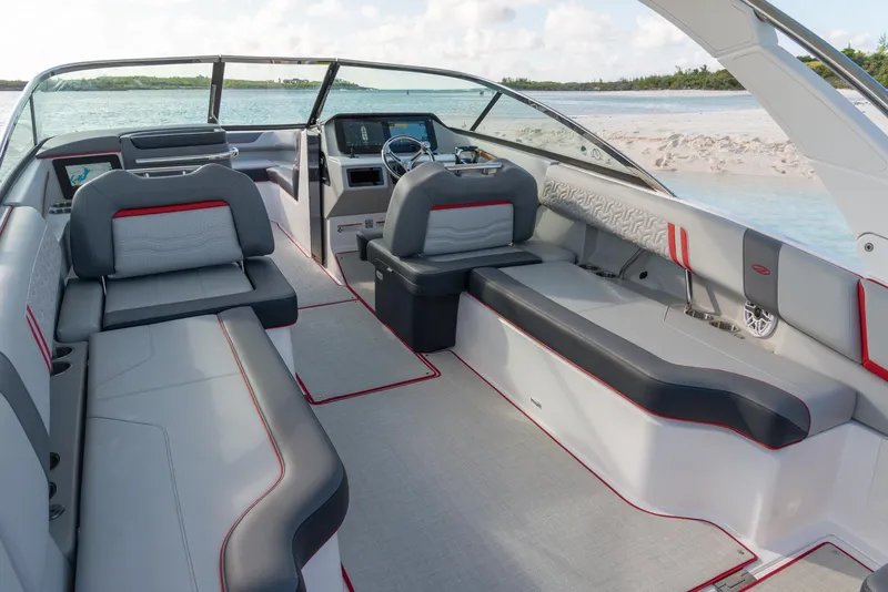 Slide: The Image of 2024 Regal LX9 boat interior with modern seating and sleek design near a sandy beach. - 13