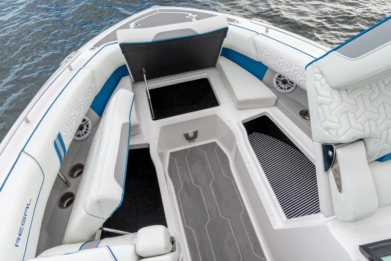 Slide: The Image of 2024 Regal LX9 boat interior with white seating, blue accents, and storage compartments. - 17