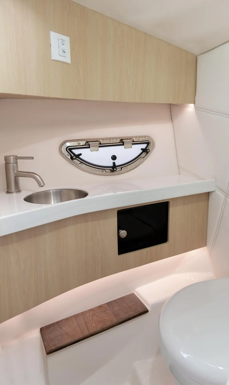 Slide: The Image of 2024 Regal LX9 boat interior with modern sink, porthole, and sleek design. - 21