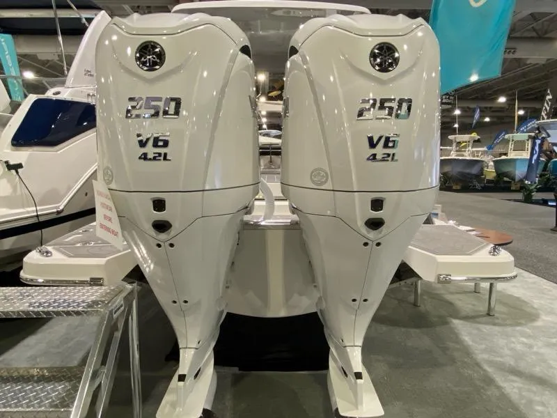 Slide: The Image of 2024 Regal LX9 boat with twin 250 V6 4.2L outboard engines displayed indoors. - 22