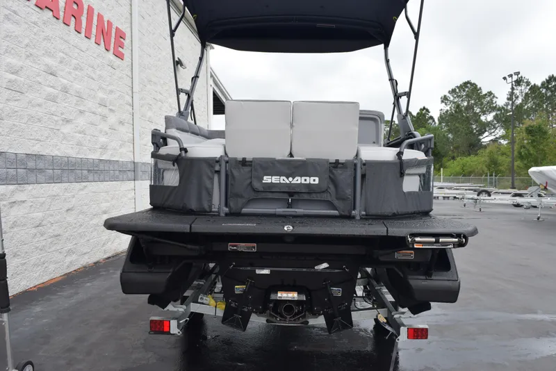 Slide: The Image of 2024 Sea-Doo Switch Sport 18 pontoon boat rear view at a marina. - 5