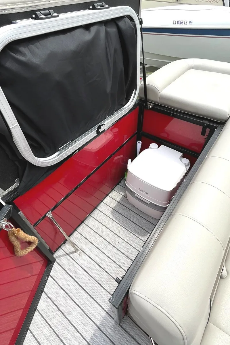 Slide: The Image of 2019 Trifecta 23C 3.0 boat interior with storage compartment and portable toilet. - 9