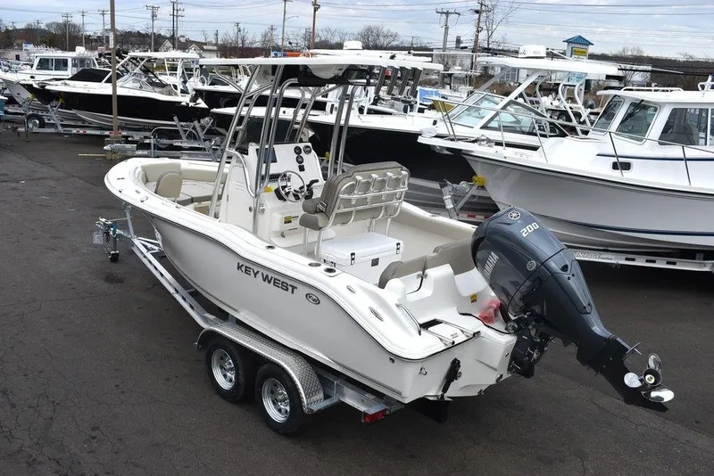 Slide: The Image of 2024 Key West 219 FS boat on trailer, docked in a marina. - 4