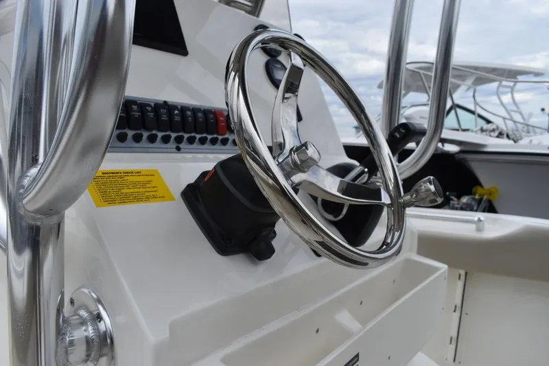 Slide: The Image of 2024 Key West 219 FS boat steering console with chrome wheel and control panel. - 41