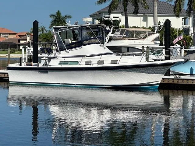 Slide: The Image of 2004 Albin 35 Command Bridge yacht docked in a marina, reflecting on calm water. - 0