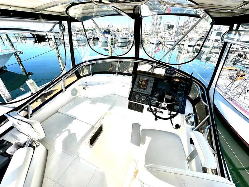 Slide: The Image of 2004 Albin 35 Command Bridge interior with helm, marina view, and modern navigation equipment. - 12