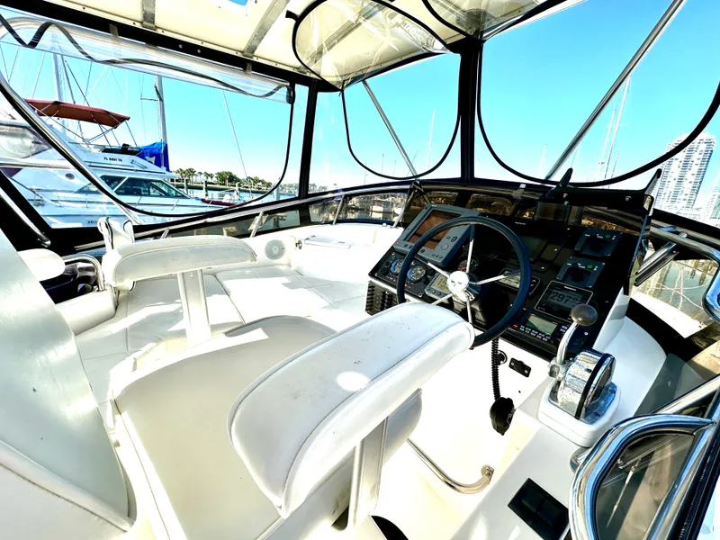 Slide: The Image of 2004 Albin 35 Command Bridge cockpit with steering wheel and control panel, docked at marina. - 16