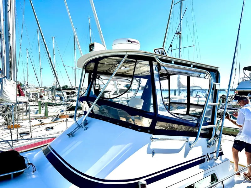 Slide: The Image of 2004 Albin 35 Command Bridge yacht docked at a marina under clear blue skies. - 2