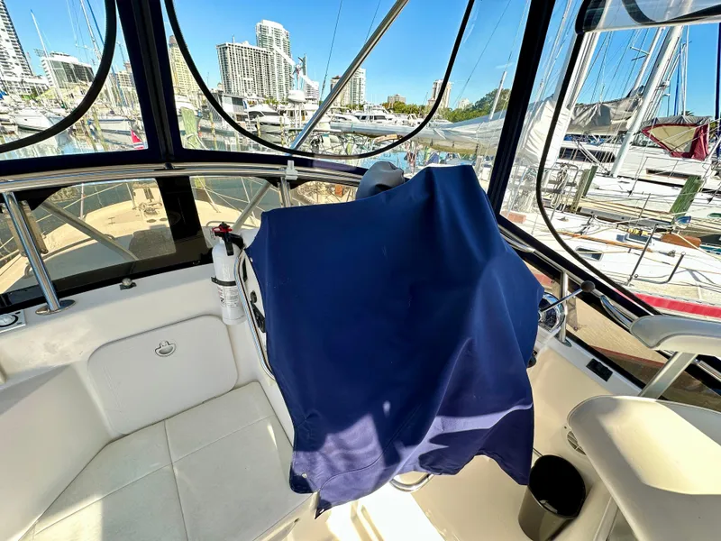 Slide: The Image of 2004 Albin 35 Command Bridge interior with marina view, featuring covered controls and seating. - 23
