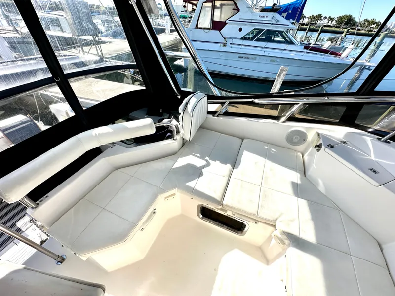 Slide: The Image of 2004 Albin 35 Command Bridge interior with white seating and marina view. - 25