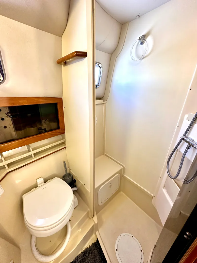 Slide: The Image of 2004 Albin 35 Command Bridge bathroom with toilet, shower, and porthole window. - 27