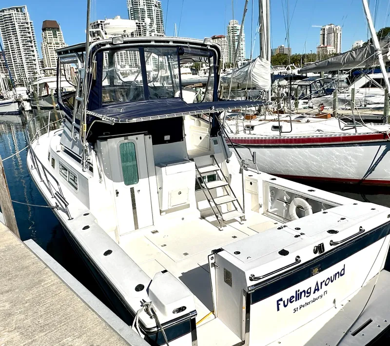 Slide: The Image of 2004 Albin 35 Command Bridge yacht docked in marina, surrounded by sailboats and city skyline. - 3