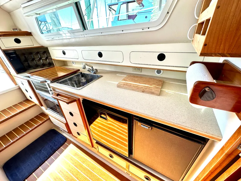 Slide: The Image of 2004 Albin 35 Command Bridge kitchen with sink, stove, and storage cabinets. - 32