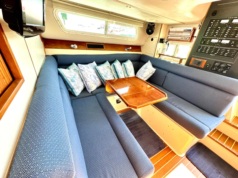 Slide: The Image of Interior of 2004 Albin 35 Command Bridge with blue seating and wooden table. - 33