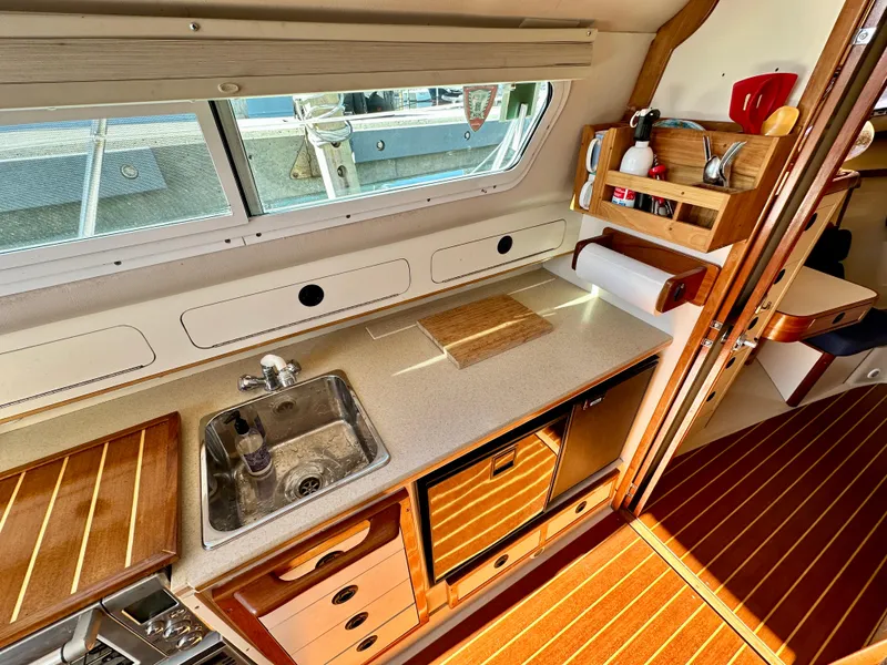 Slide: The Image of 2004 Albin 35 Command Bridge interior kitchen with sink, countertop, and wooden cabinetry. - 38