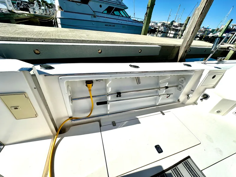 Slide: The Image of 2004 Albin 35 Command Bridge boat deck with open storage compartment and yellow power cable. - 47