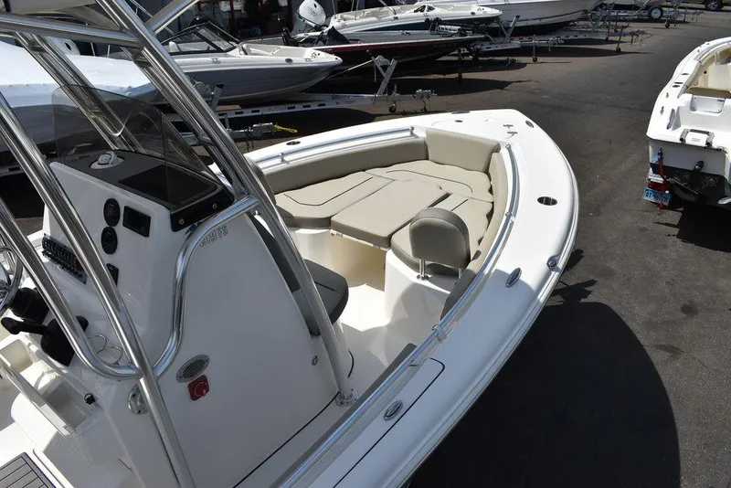 Slide: The Image of 2024 Key West 219 FS boat with cushioned seating and console, docked in a marina. - 18