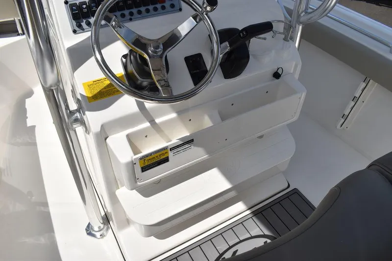 Slide: The Image of 2024 Key West 219 FS boat console with steering wheel and storage compartments. - 38